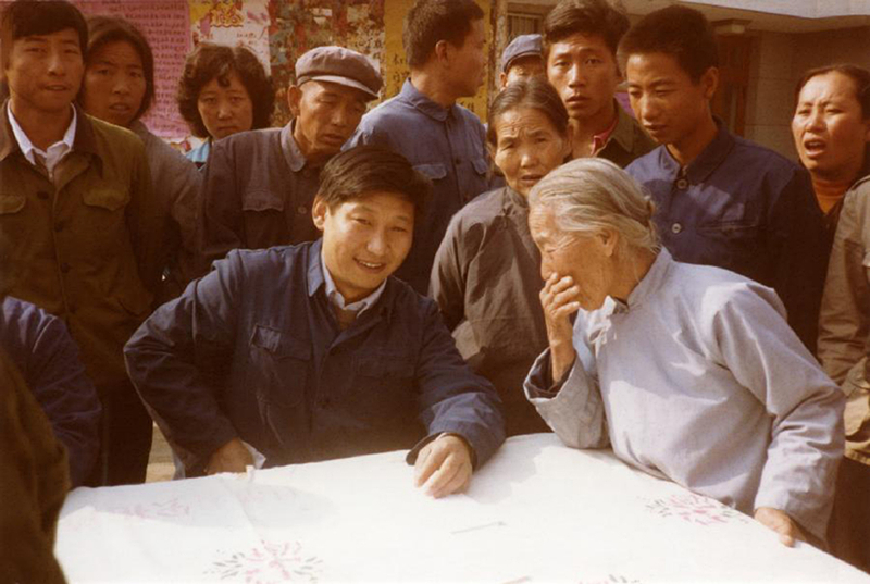 1983年，時(shí)任河北正定縣委書(shū)記的習近平（前排居中），臨時(shí)在大街上擺桌子聽(tīng)取老百姓意見(jiàn)。